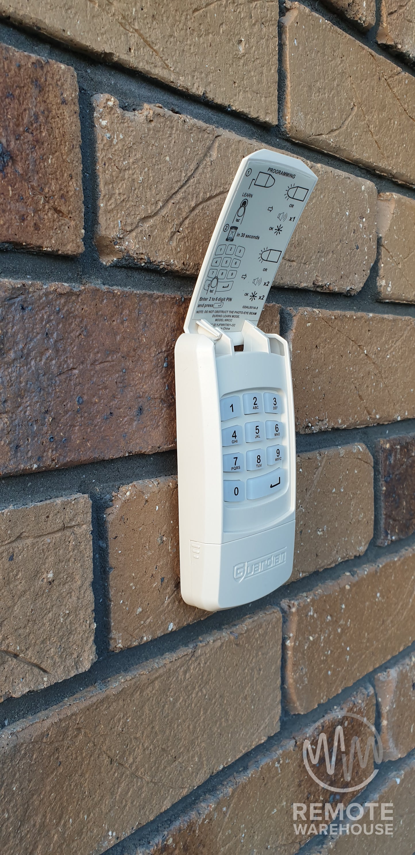 Guardian WKCC garage door keypad fitted on brick wall of house